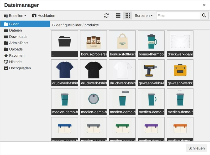 Fenster „Dateimanager“ mit den Bereichen Bilder, Dateien, Downloads, AdminTools und Uploads links, oben „Erstellen“, „Hochladen“, Ansichtsknöpfe, „Sortieren“ und Filterfeld; geöffnet ist der Ordner „Bilder / quellbilder / produkte“ in der Kachelansicht mit Vorschaubildern von T-Shirts, Werkzeug, Thermobechern und Brotdosen
